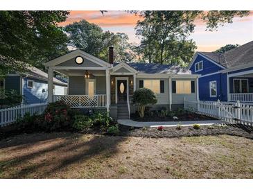 Charming craftsman bungalow with gray siding, white picket fence, and a welcoming front porch at 910 E Lake Dr, Decatur, GA 30030