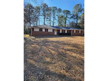 Brick ranch house with mature trees and a large yard at 2789 Odum St, Snellville, GA 30078