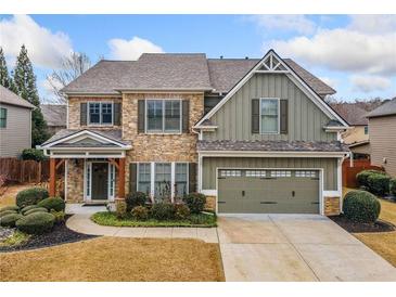 Charming two-story home with stone and siding exterior, front porch, and attached two-car garage at 8195 Majors Glen Ct, Cumming, GA 30041