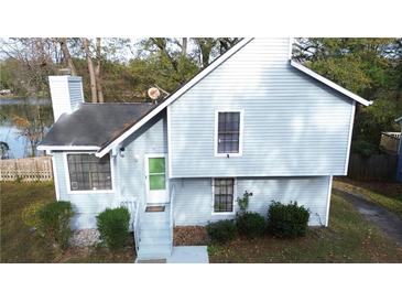 Two-story house with light gray siding, green door and landscaping at 1077 Mainstreet Valley Dr, Stone Mountain, GA 30088