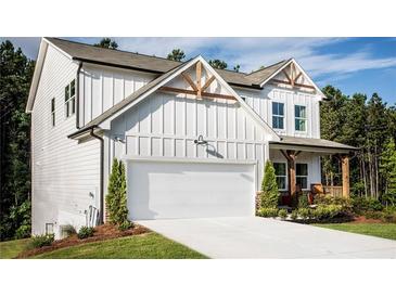 Two-story farmhouse-style home with white siding, large garage, and landscaping at 126 Henley St, Canton, GA 30114
