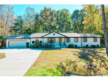 White ranch house with attached garage and landscaped yard at 2230 Old Fountain Rd, Lawrenceville, GA 30043