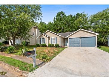 Charming single-story home with a two-car garage and landscaped front yard at 2921 Ward Lake Way, Ellenwood, GA 30294