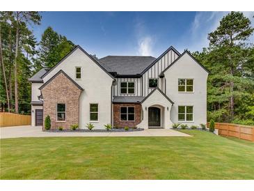 Two-story home with brick and white exterior, a large front yard, and a three-car garage at 2626 Sardis Way, Buford, GA 30519