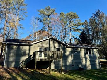 Gray house back with deck and stairs, surrounded by trees at 4212 Anneewakee Rd, Douglasville, GA 30135