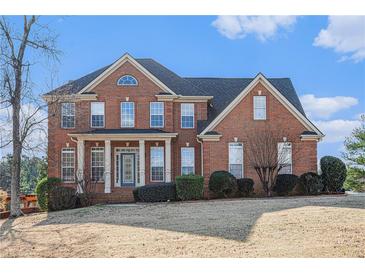 Brick two-story house with a large front yard and manicured landscaping at 2612 Grove Park Ln, Conyers, GA 30094