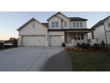 Two-story house with three car garage and landscaped front yard at 227 Wild Ginger Bnd, Woodstock, GA 30188