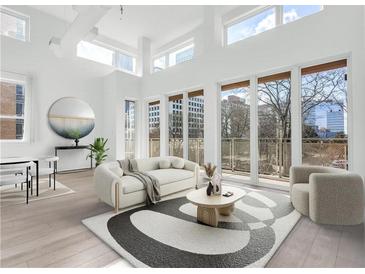 Bright living room with high ceilings, large windows, and hardwood floors at 775 Juniper Ne St # 619, Atlanta, GA 30308