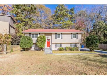 Two-story home with red door, shrubs, and green lawn at 633 Larchmont Nw Cir, Atlanta, GA 30318