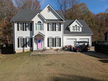 Two-story house with white siding, black shutters, and a pink door at 405 Baneberry Bnd, Peachtree City, GA 30269