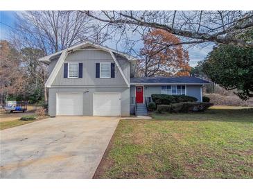 Charming two-story home with gray brick and siding, a red door, and a two-car garage at 1151 Martin Rd, Stone Mountain, GA 30088
