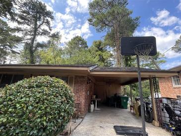 Brick ranch house with carport, basketball goal, and mature landscaping at 2405 Clifton Springs Rd, Decatur, GA 30034