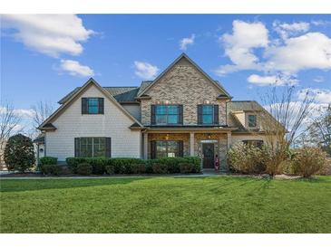 Beautiful two-story home with a brick and siding facade, lush green lawn, and inviting front porch at 5705 Windjammer Pt, Cumming, GA 30041