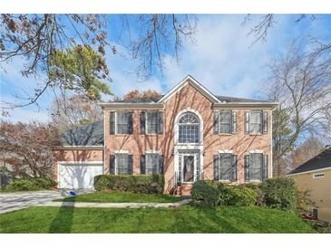 Brick house with two-car garage and landscaped lawn at 6320 Murets Rd, Alpharetta, GA 30022