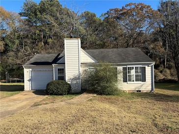 Charming single-story home with a chimney, attached garage, and front yard at 4262 Catalpa Park, Ellenwood, GA 30294
