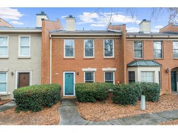 Charming brick townhome with a teal front door and well-maintained landscaping at 4124 Islington Way, Duluth, GA 30096