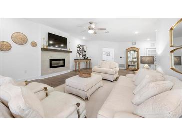 Bright living room with fireplace, hardwood floors, and comfortable seating at 3211 Orwell Way # 4302, Cumming, GA 30041