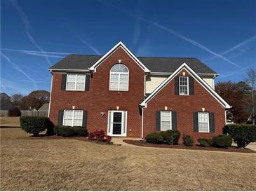 Brick and vinyl two-story home with landscaping and a spacious lawn at 2236 Mission Ridge Se Dr, Conyers, GA 30013