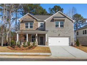 Inviting two-story home with a charming front porch and a two-car garage at 1495 Auburn Glen Rd, Dacula, GA 30019