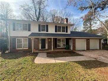 Charming two-story home with a brick and siding exterior, attached two-car garage, and front yard at 517 Fond Du Lac Dr, Stone Mountain, GA 30088