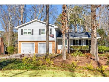 Two-story house with two-car garage, and a nicely landscaped yard at 5509 Rodney Ln, Stone Mountain, GA 30087