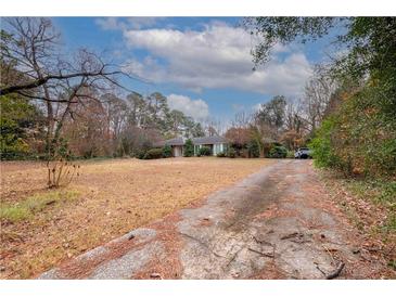 Single-story home with driveway, front yard, and trees at 750 Mount Vernon Hwy, Atlanta, GA 30327