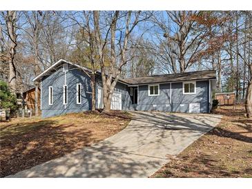 Charming blue two-story home with a driveway and surrounding trees at 2960 Valley Ne Ct, Conyers, GA 30012