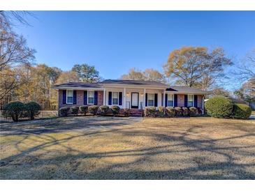 Charming brick ranch home with a covered front porch and large front yard at 8450 Union Grove Rd, Lithonia, GA 30058