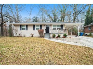 Ranch style home with brick facade, carport, and landscaped lawn at 876 Hutchens Se Rd, Atlanta, GA 30354