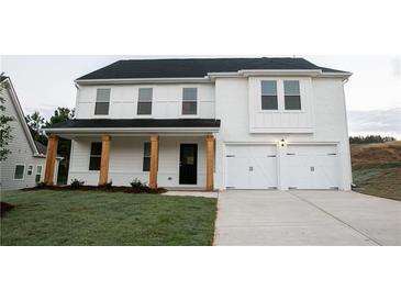 Charming two-story home with white brick exterior, wooden columns, and a two-car garage at 333 Orwell Dr, Social Circle, GA 30025