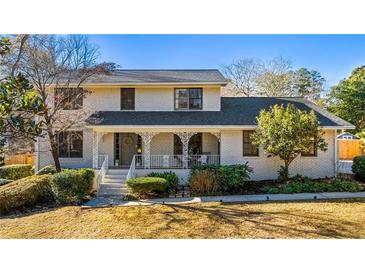 Charming two-story home with white brick exterior, covered porch, and landscaped yard at 2624 Whiteleigh Ne Dr, Atlanta, GA 30345