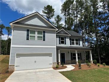 Charming two-story home with a welcoming front porch and a two-car garage at 5032 Falcon Pt, Douglasville, GA 30135