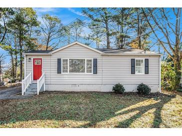 Charming ranch home with a red door and well-manicured lawn at 1786 Ledo Ave, Decatur, GA 30035