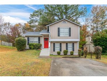 Two-story house with red door, landscaping, and driveway at 3972 Glenwood Downs Ln, Decatur, GA 30035