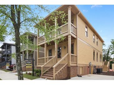 Tan two-story house with wrap-around porch and stone accents at 110 Hogue St, Atlanta, GA 30312