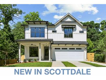 Two-story farmhouse-style home with white siding, black accents, and a two-car garage at 3208 Altacrest Dr, Scottdale, GA 30079