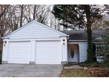 Three-car garage, white exterior, landscaping at 2688 Crystal Ln, Lawrenceville, GA 30044