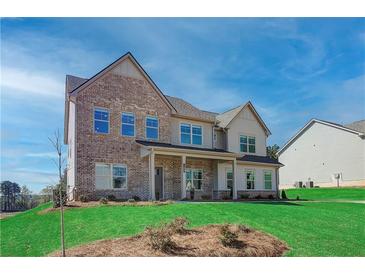 Brick two-story house with a landscaped lawn and a partially visible neighboring house at 138 Frontier Way, Mcdonough, GA 30253