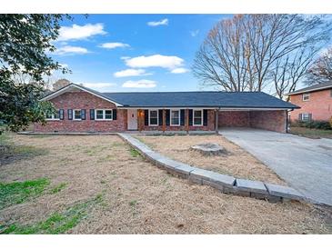 Brick ranch house with carport and landscaped yard at 1658 Brockett Rd, Tucker, GA 30084