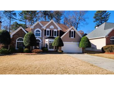 Two-story house with stone accents and landscaping; attached garage at 195 Brookhollow Trce, Johns Creek, GA 30022