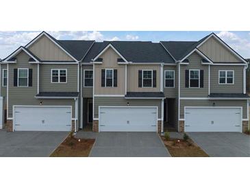 Three-unit townhome building with attached garages and neutral color palette at 1080 Cades Walk, Lawrenceville, GA 30045