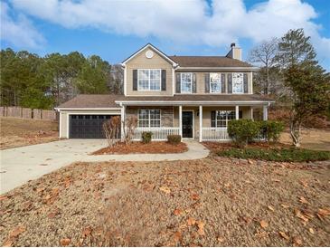 Two-story house with a stone facade, attached garage, and front porch at 3170 Victoria Ridge Ct, Loganville, GA 30052