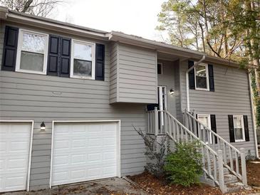 Gray two-story house with attached garage and black shutters at 1415 Chedworth, Stone Mountain, GA 30083