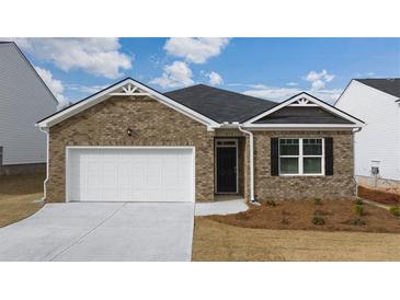 Brick house with a two-car garage and landscaping at 540 Whitman Ln, Stockbridge, GA 30281