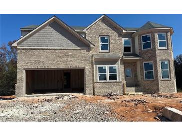 Brick two-story house with a large garage and landscaping at 316 Rodeo Dr, Auburn, GA 30011