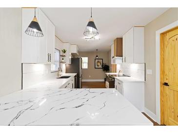 Modern white kitchen with quartz countertops and stainless steel appliances at 2191 Essex Sw Ave, Atlanta, GA 30311