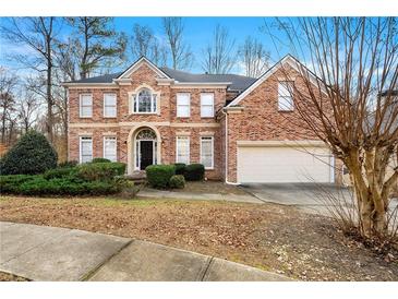 Brick two-story house with attached garage and manicured landscaping at 7250 Weber St, Atlanta, GA 30349