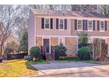 Tan and stone exterior of a charming townhome with manicured landscaping at 341 Red Oak Sw Run, Marietta, GA 30008