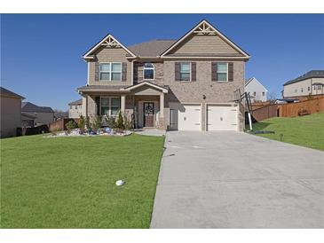 Two-story house with stone and shingle accents, two-car garage, and landscaped lawn at 2790 Ridge Manor Dr, Dacula, GA 30019