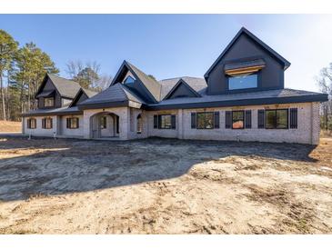 Brick house with a large front porch and a dark-colored roof at 1730 Etchison Spur, Loganville, GA 30052